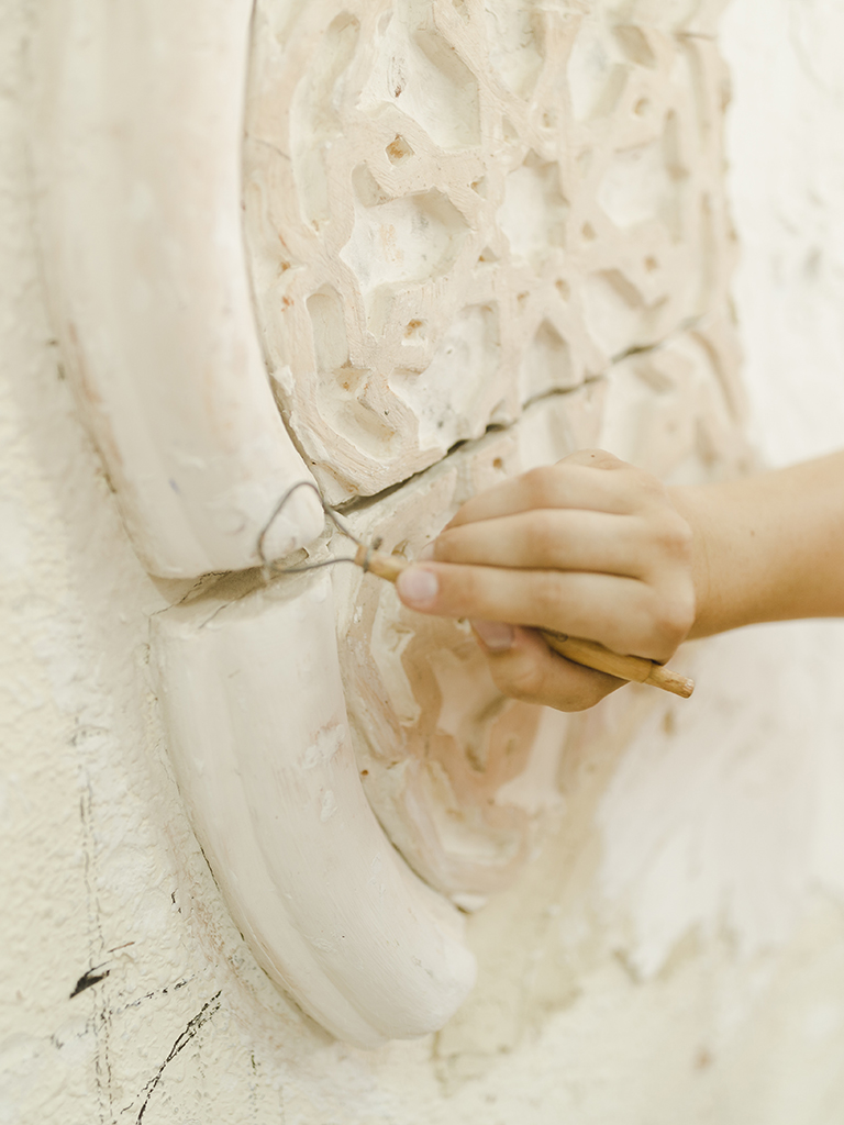 close-up-hand-using-tool-carving-wall